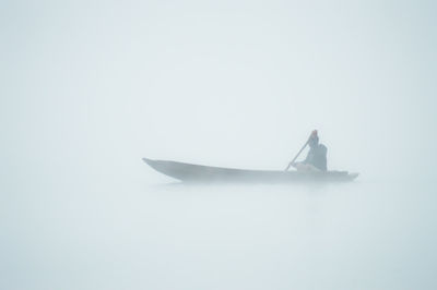 Person on boat against sky over white background