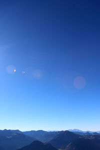 Scenic view of mountains against blue sky