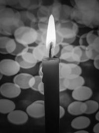 Close-up of lit candle against black background