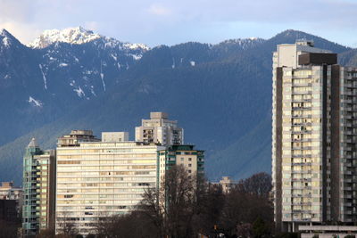 Buildings in city against cloudy sky