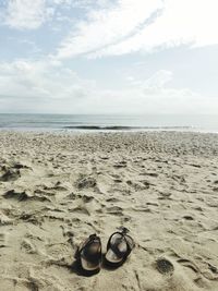 High angle view of shoes on beach against sky