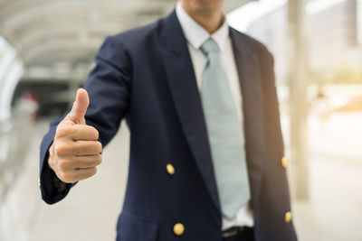 Midsection of businessman gesturing at office