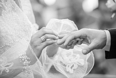 Black and white bride and groom exchanging of the wedding rings