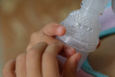 Cropped image of patient inhaling through oxygen mask in hospital