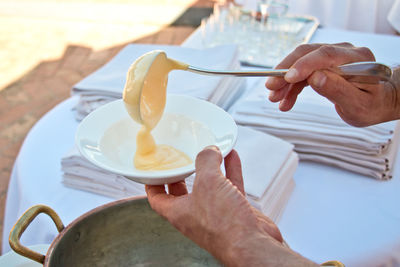 Midsection of man holding ice cream on table