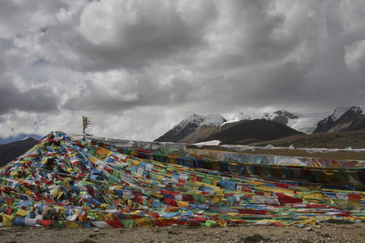 Multi colored flags on mountain against sky