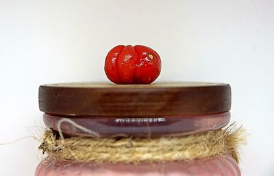 Close-up of heart shape on red table against white background
