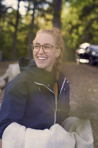 Smiling young woman holding towel while looking away