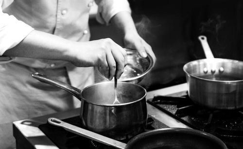 Midsection of man preparing food in kitchen