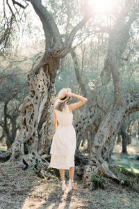 Full length of woman standing on tree trunk