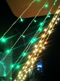 Low angle view of illuminated lighting equipment at night