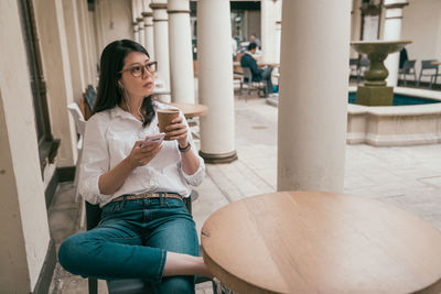 Woman listening music while having coffee in cafe