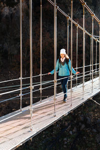 Woman conquering her fear on a bridge