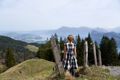 Man standing by plants on mountain against sky