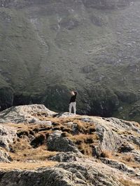 Man standing on rock against mountain