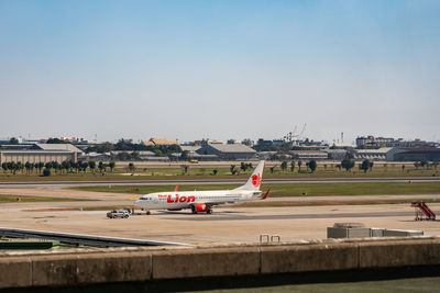 Airplane on airport runway against sky