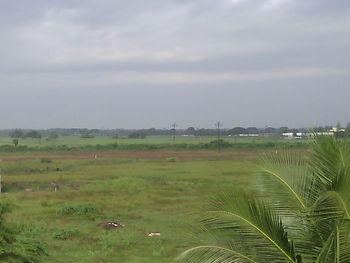 Scenic view of field against cloudy sky