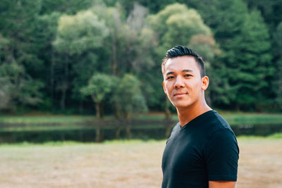 Portrait of man standing against trees outdoors