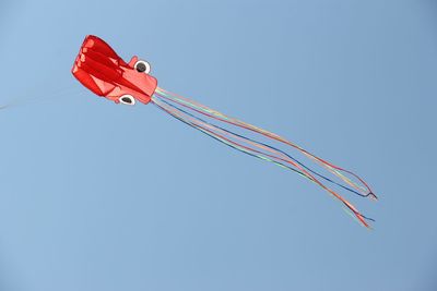 Low angle view of kite flying against clear blue sky