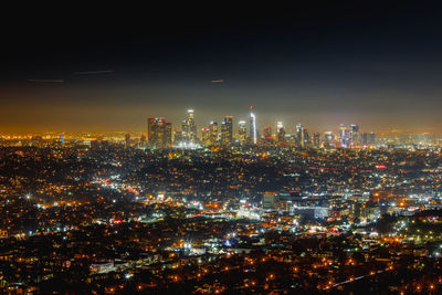 Illuminated cityscape against sky at night