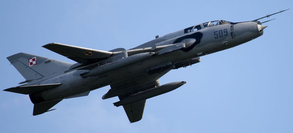 Low angle view of airplane flying against blue sky