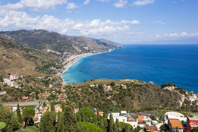 Scenic view of sea by buildings against sky