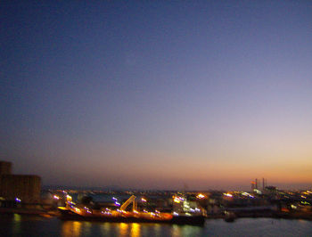 Illuminated cityscape against sky at night