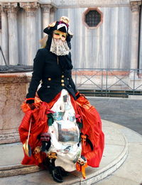 Portrait of young woman standing against built structure