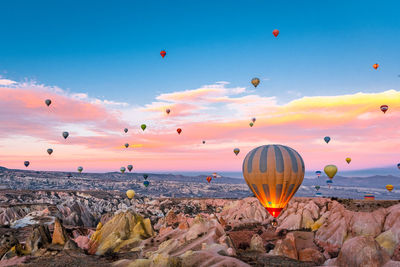 Hot air balloons flying over rocks