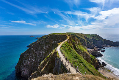 Footpath on mountain by sea against sky