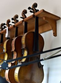 Low angle view of violins hanging against wall