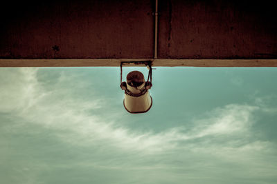 Low angle view of hanging light against wall