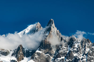 Scenic view of snowcapped mountains against blue sky