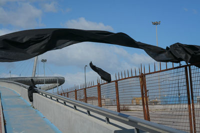 Low angle view of birds on railing against sky