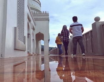 Low angle view of people walking on floor by water