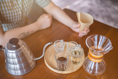 Cropped hand of woman holding coffee on table