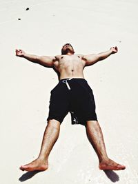 Low angle view of shirtless man at beach