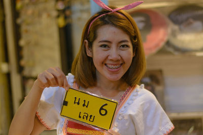 Portrait of smiling woman holding paper