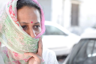 Close-up of thoughtful woman covering face with sari