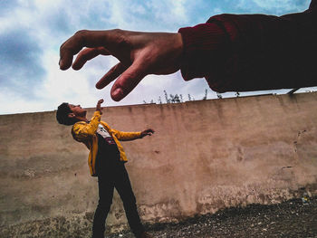 Men playing with hands against sky