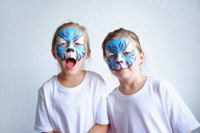 Two sister girls with aqua makeup in the form of a blue water zodiac tiger depict a tiger, 2022 year
