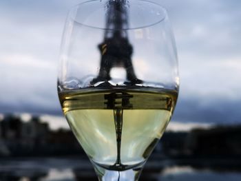 Close-up of glass of water against sky