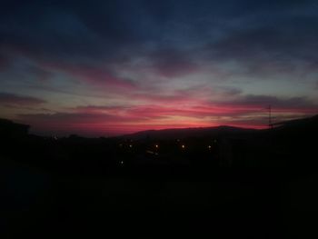 Silhouette landscape against dramatic sky at sunset