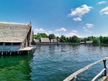 Scenic view of lake by building against sky