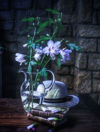 Close-up of flower pot on table against wall