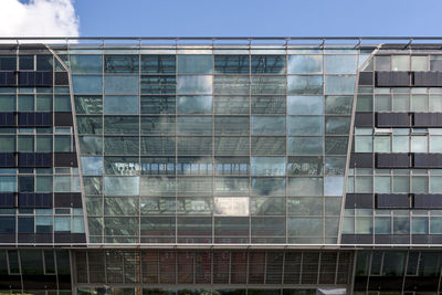 Low angle view of glass building against sky