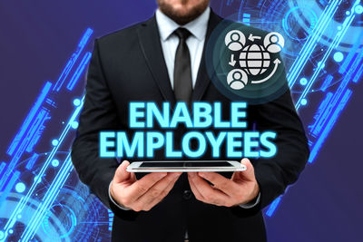 Low angle view of man using smart phone against blue background
