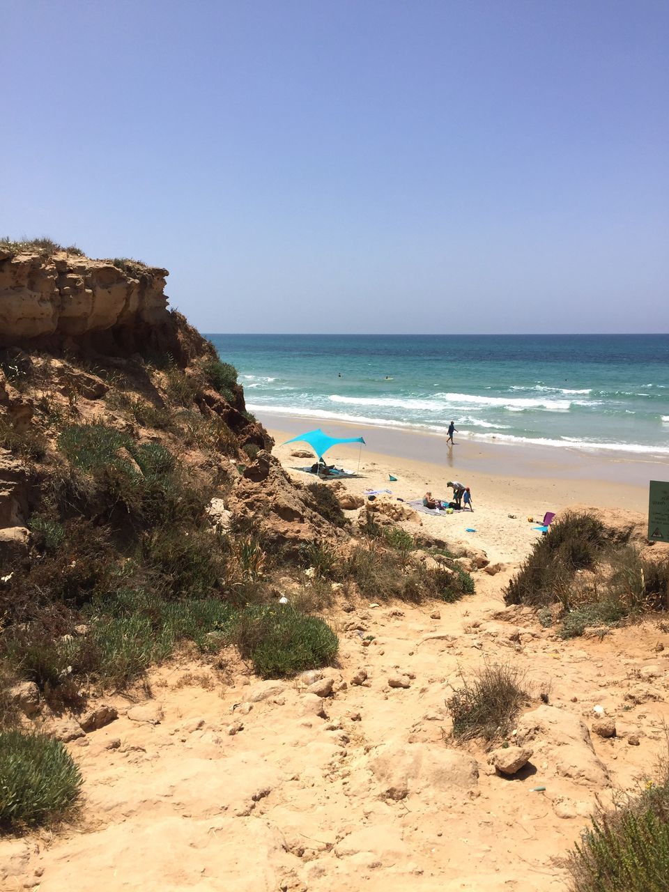 sea, beach, horizon over water, nature, water, sand, clear sky, scenics, beauty in nature, rock - object, tranquility, sky, day, outdoors, cliff, vacations, blue, no people, wave