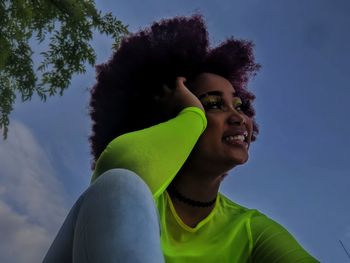 Portrait of smiling young woman against sky