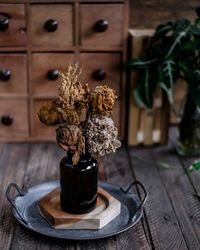 Close-up of potted dried flowers on table